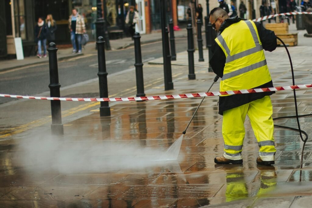 Technician using a pressure washer on an outdoor surface